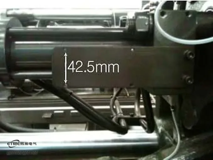 Measuring the machine mounting hole pitch with a caliper, reading 42.5 mm